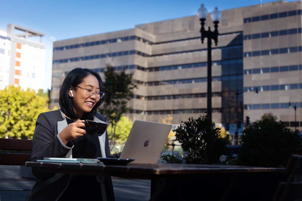 Student drinking coffee at cafe while working