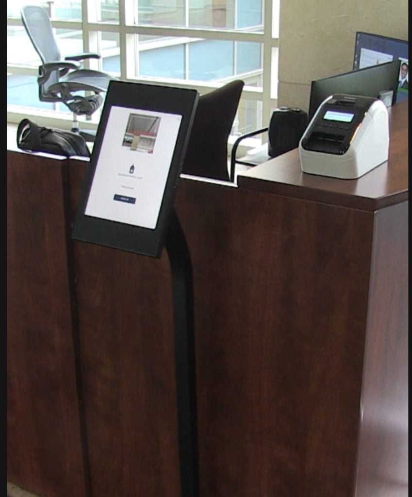 iPad check in system next to front desk and badge printer